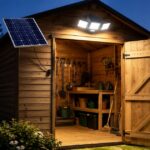 Solar lighting shed with a bright LED light illuminating the wooden shed at night and a solar panel mounted outside.